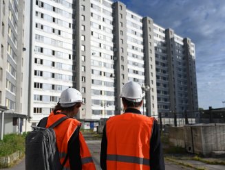 ouvriers du bâtiment devant une tour d'habitation