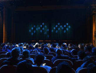 Salle de spectacle remplie d'un public regardant la scène 