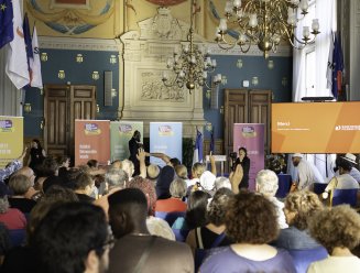 Le maire devant un public levant la main