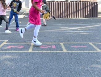 Enfant jouant à la marelle dans une cours de récréation